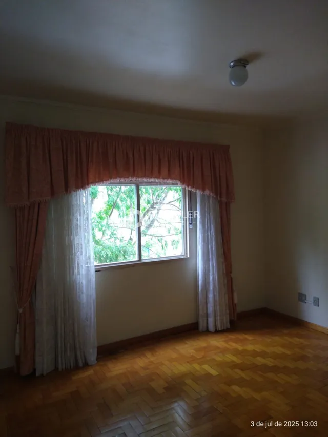 Foto de um cômodo interno com janela e piso de madeira.
