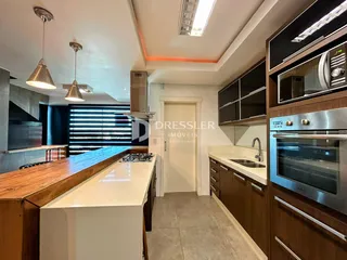 Foto de uma cozinha moderna com armários de madeira e bancadas brancas.