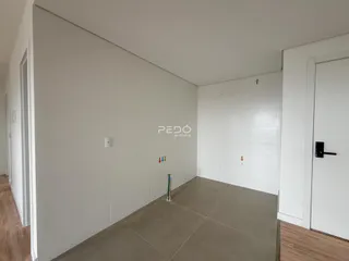 Vista de um corredor interno com paredes brancas e piso de cerâmica clara.