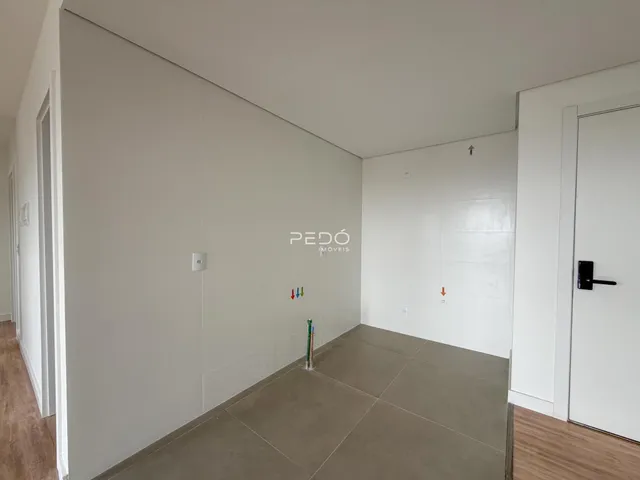 Vista de um corredor interno com paredes brancas e piso de cerâmica clara.