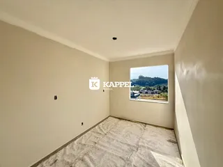 Vista interna de um cômodo com paredes claras e piso de carpete.