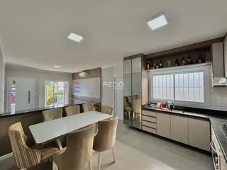 Vista de uma sala de jantar com mesa e cadeiras em um imóvel no Brasil.