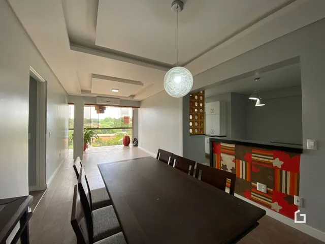 Ambiente interno com mesa de jantar e vista para o exterior.