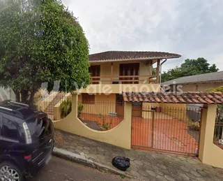 Fachada de uma residência em Lajeado, Brasil, com portão de madeira.
