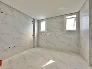 Interior de um cômodo com revestimento de mármore nas paredes e piso.