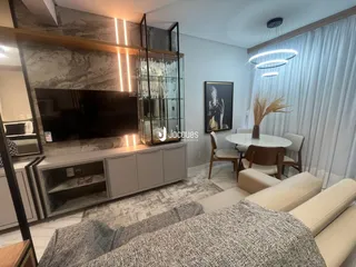 Sala de estar moderna com painel de TV e janelas amplas.
