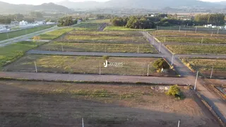 Vista aérea de um terreno aberto com vegetação e estradas.