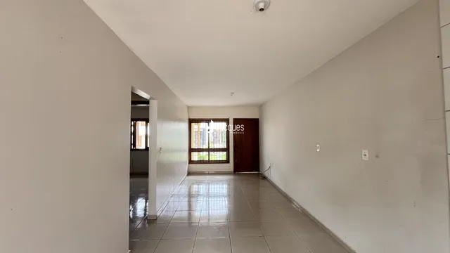 Corredor interno de uma residência com piso de cerâmica.