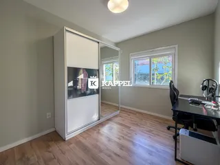 Foto de um ambiente interno com piso de madeira e uma janela na sala.