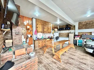 Interior de uma cozinha com armários de madeira e mesa de jantar em um imóvel em Lajeado, Brasil.
