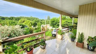 Vista de uma varanda com vegetação exuberante ao fundo.