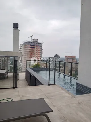Vista de uma área de piscina e sacada em um imóvel.