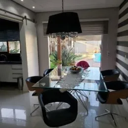 Foto de uma mesa de jantar com cadeiras em um ambiente interno.