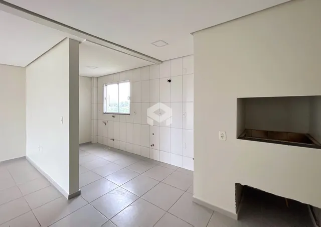 Corredor interno com paredes brancas e piso cinza em uma propriedade.