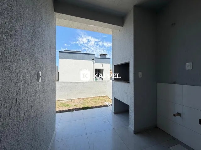 Hall de entrada com piso de cerâmica e vista para o quintal.