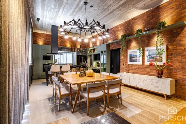 Uma sala de jantar com mesa de madeira e iluminação central.