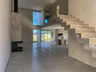 Vista ampla de um ambiente interno com escadaria e lareira em uma residência.