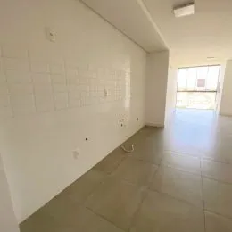 Hall de entrada com paredes brancas e piso claro.