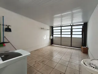 Ambiente interno de uma sala com piso de cerâmica e porta de vidro.