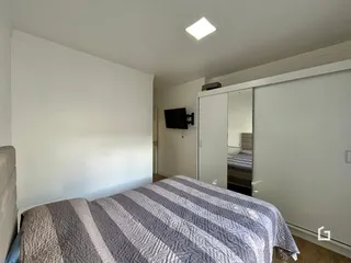 Quarto com cama e armário em ambiente claro.