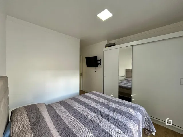 Quarto com cama e armário em ambiente claro.
