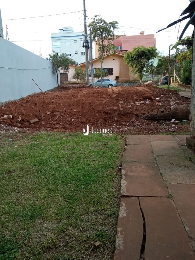 Vista da propriedade com terra revolvida e grama no primeiro plano.