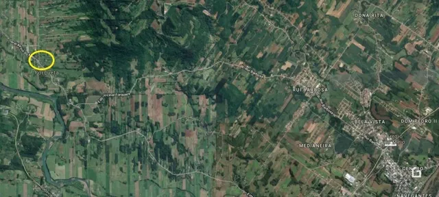 Vista aérea de uma área rural com vegetação densa e campos.