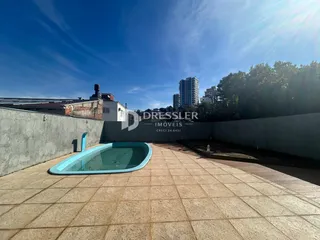 Área externa com piscina e piso de cerâmica.