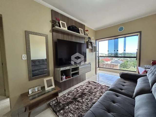 Sala de estar com sofá e televisão em um imóvel no Brasil.