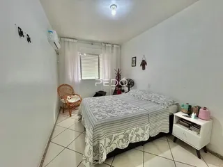Quarto com cama e janela em ambiente claro.