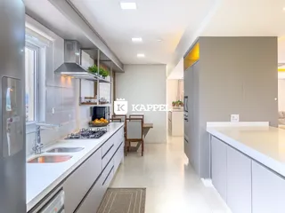 Foto de uma cozinha moderna com armários brancos e bancadas claras.