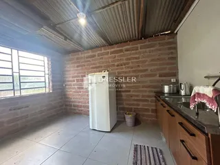 Interior de uma sala com parede de tijolos aparentes e piso de cerâmica.