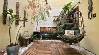 Sala de estar com piso de madeira e poltrona pendurada.