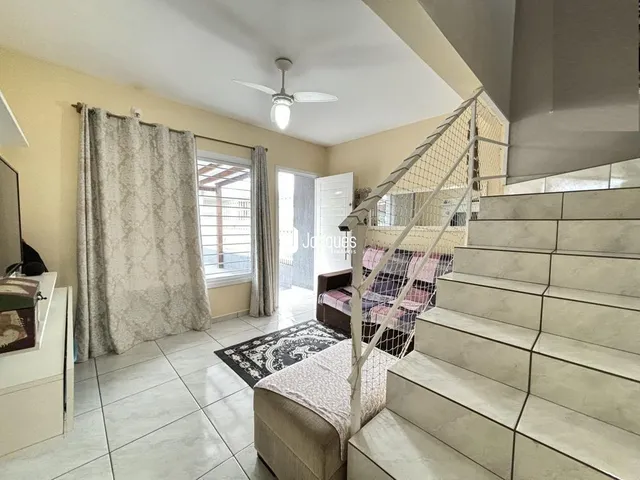 Interior de uma sala com piso de cerâmica e escadaria.