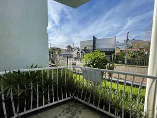 Vista da área externa com vegetação e cerca de madeira.