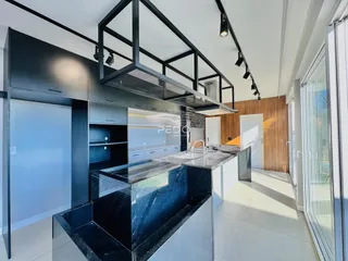 Foto de uma cozinha moderna com ilha de granito preto.