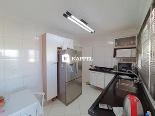 Cozinha moderna com armários brancos e eletrodomésticos de aço inoxidável.