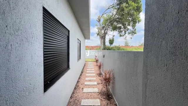 Vista lateral da fachada de uma residência com um caminho de pedras.
