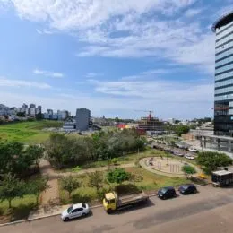 Vista externa de uma área verde com paisagem ao fundo.