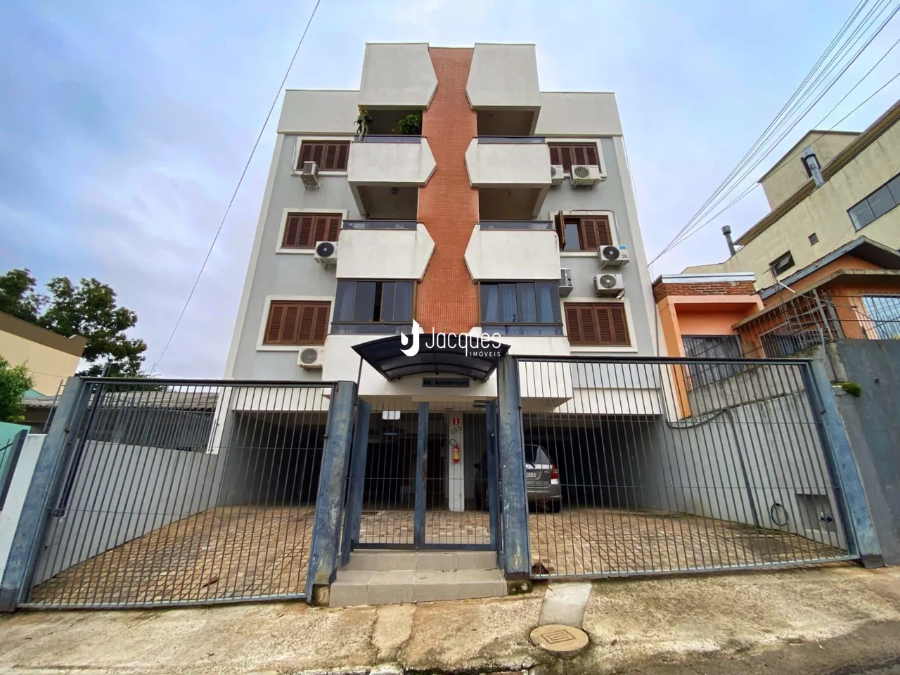 Fachada de um prédio residencial em Lajeado, Brasil, com portão de ferro.