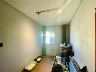 Quarto com piso de madeira e janela em Lajeado, Brasil.