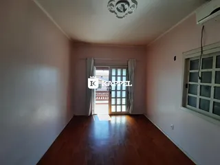 Foto de um cômodo interno com paredes claras e piso de madeira.