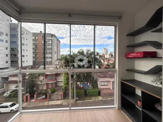 Vista da sala de estar com grandes janelas de vidro mostrando um quintal.