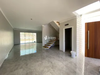 Sala de estar ampla com piso de porcelanato e acesso a uma área externa.