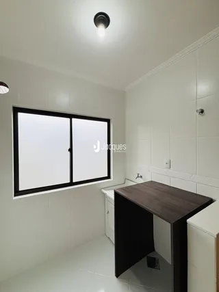 Ambiente interno de um banheiro com piso e paredes brancas.