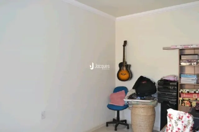 Parede interna de uma residência com um instrumento musical apoiado.