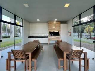 Ambiente de sala de jantar com grandes janelas de vidro.