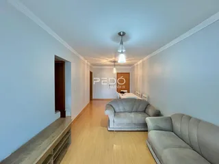 Sala de estar com piso de madeira clara e dois sofás.