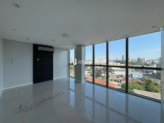 Sala ampla com vista panorâmica da cidade através de grandes janelas.