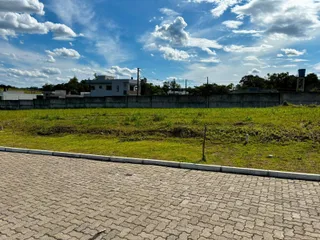 Vista externa da propriedade mostrando um gramado e uma cerca de concreto.